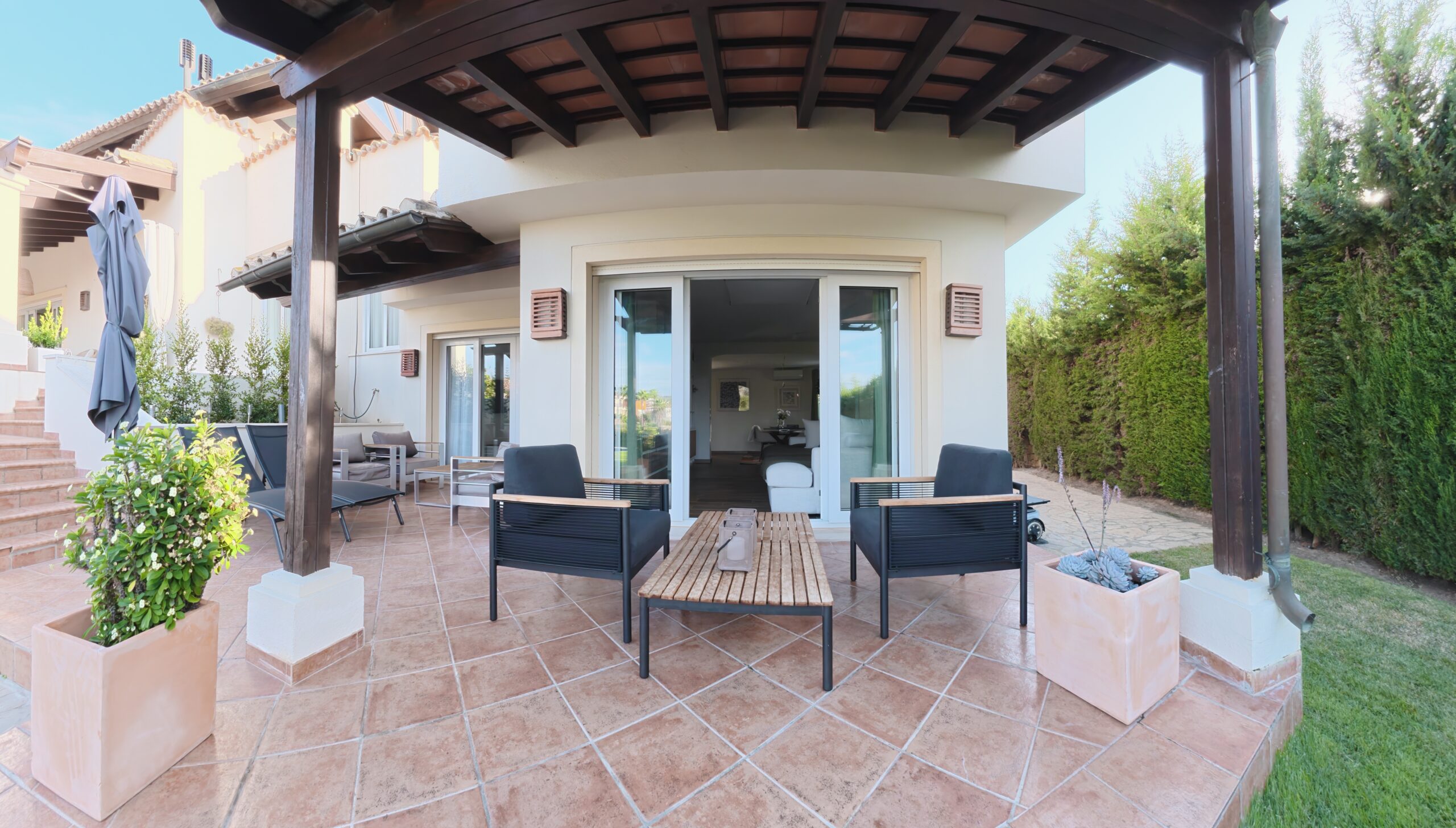 Covered private terrace at Bluehorizon Alcaidesa with seating and access to the garden